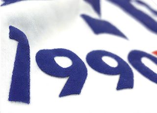 ぷっくりと盛り上がった青い数字がプリントされた白いTシャツ