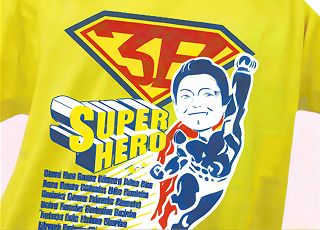 スーパーヒーロー風のイラストがプリントされた黄色いTシャツ