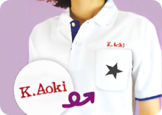 胸に黒い星と「K.Aoki」が刺繍された白いポロシャツ