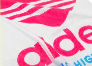 ピンク色のロゴがプリントされた白いTシャツ